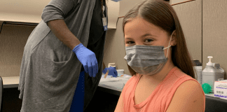 Making Decisions: We Can Do This A masked girl about to get her COVID vaccine.