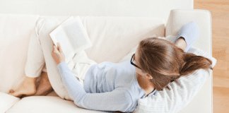 A woman on the couch reading.