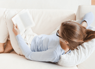 A woman on the couch reading.