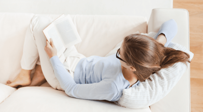 A woman on the couch reading.