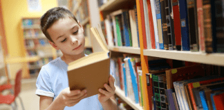 For the Love of Reading A boy reading a book in the library.