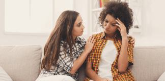 Why Don’t I See What My Friends See in Me? A woman comforting another woman while sitting on a couch.