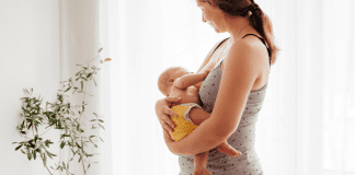 The Forgotten New Mom – How America Is Failing Its Mothers A woman postpartum holding a baby.