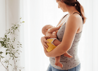 A woman postpartum holding a baby.
