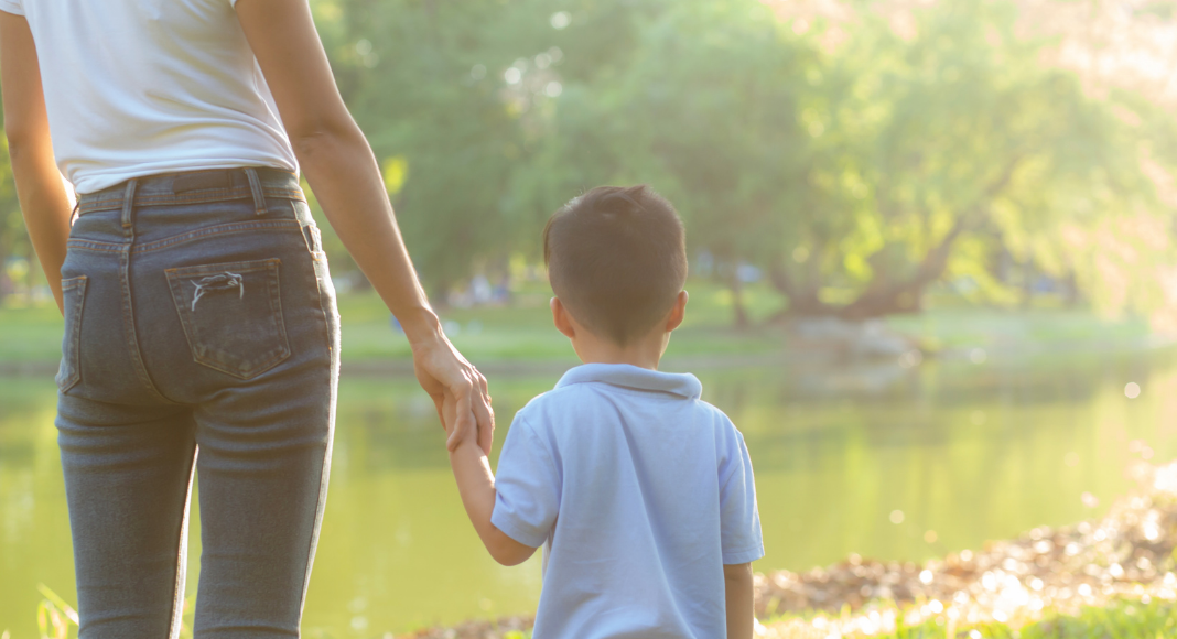 A mom holding hands with her son.