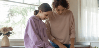 A woman cooking with her teen.