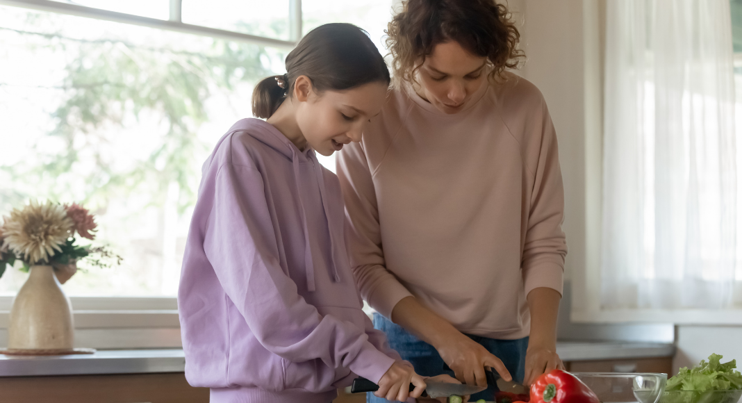 A woman cooking with her teen.