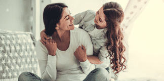 I Am in Control (Day) A girl hugging her mom from behind.