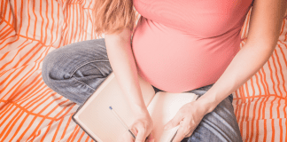 A pregnant woman writing a birth plan.