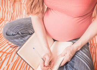 A pregnant woman writing a birth plan.