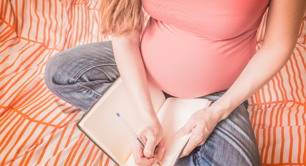 A pregnant woman writing a birth plan.