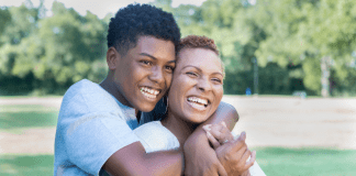 A college-age son hugging his mom.