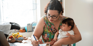 A working mom holding a baby.