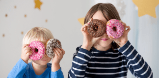 Kids holding doughnuts over their eyes.