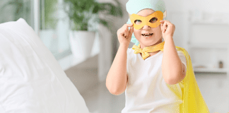 September is Childhood Cancer Awareness Month A child with cancer dressed in a mask and yellow cape.