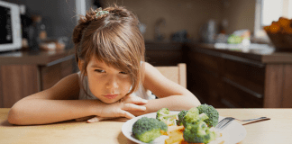 A girl refusing to eat her vegetables.