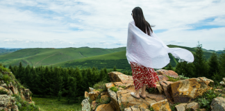 A woman standing on a precipice.