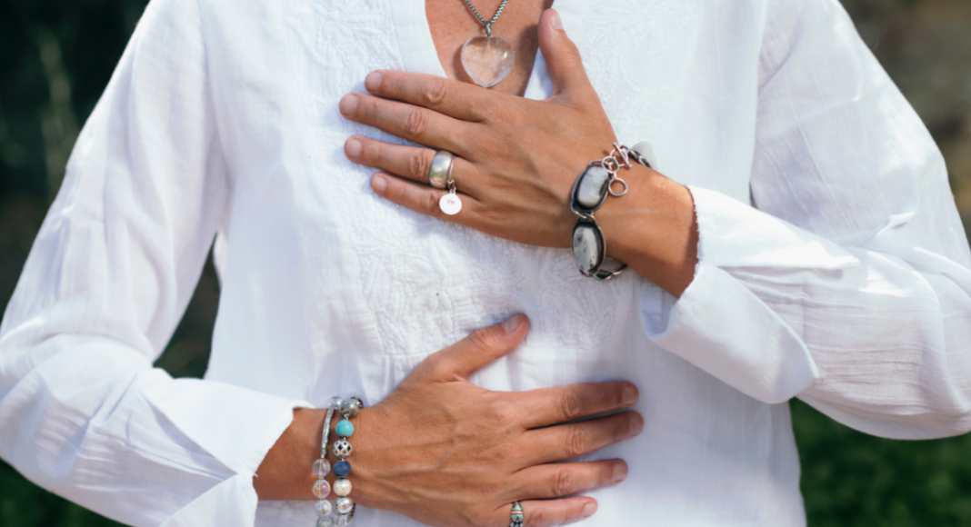 A woman holding her chest and stomach in gratitude.