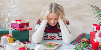 How to Thrive Amidst Holiday Stress A frustrated woman wrapping holiday gifts.