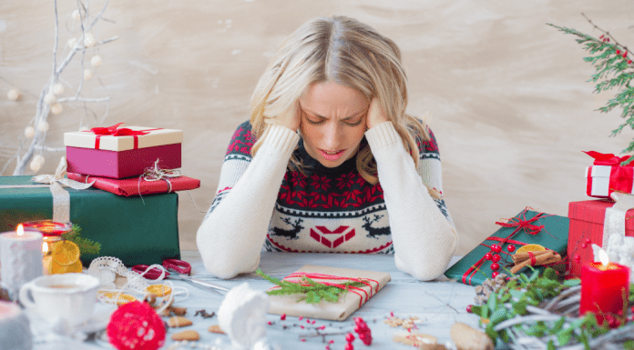 A frustrated woman wrapping holiday gifts.