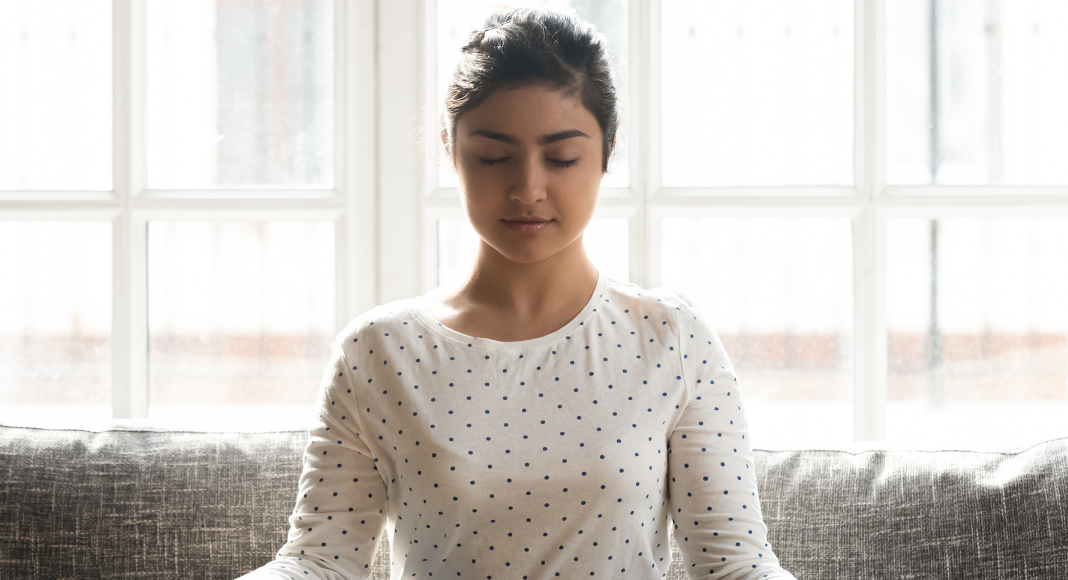 A woman taking a deep breath.