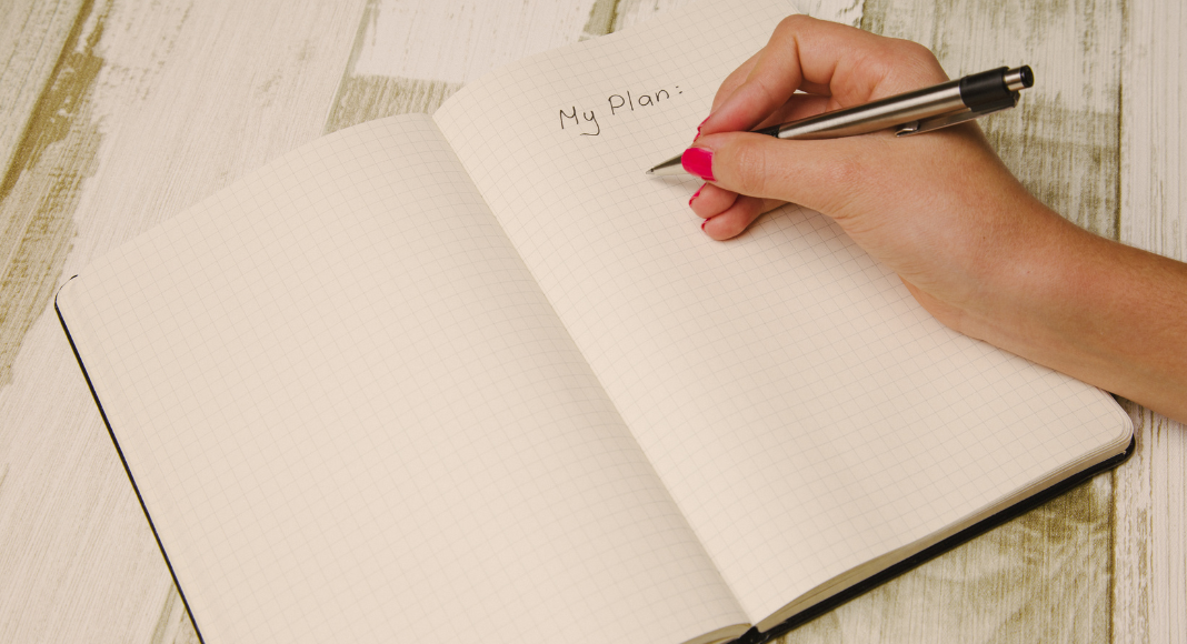 Writing down a plan for the new year in a journal. 