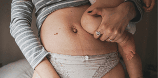 This Will Not Be the Year I Fix My “Mom Bod” A woman showing her postpartum mom bod.