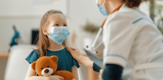 Preparing for Surgery A girl holding a teddy bear being prepared for surgery.