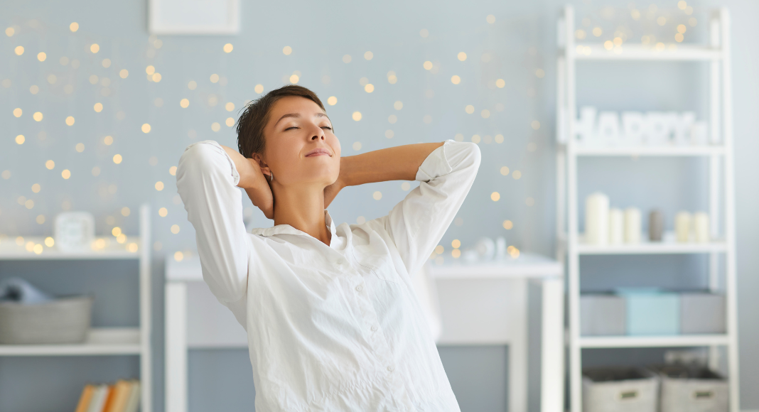 A woman trying to take a break from working by closing her eyes and leaning back in her chair. 