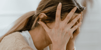 How To Overcome Negative Thinking A woman holding her face.