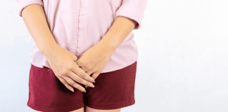 A woman folding her hands in front of her body.