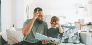 A dad reading a book to his son.
