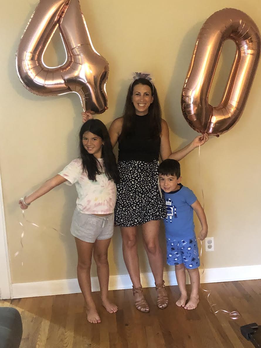 A woman holding 4-0 balloons