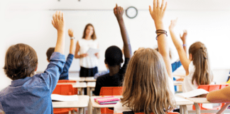 Students raising their hands in class.