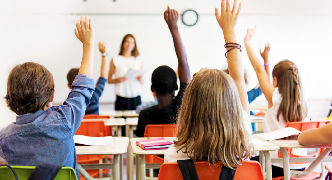 Students raising their hands in class.