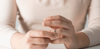 Divorce Isn’t Easy For Moms A woman removing her wedding ring.