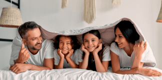 Excess and Keeping Up With The Joneses A family under a blanket.