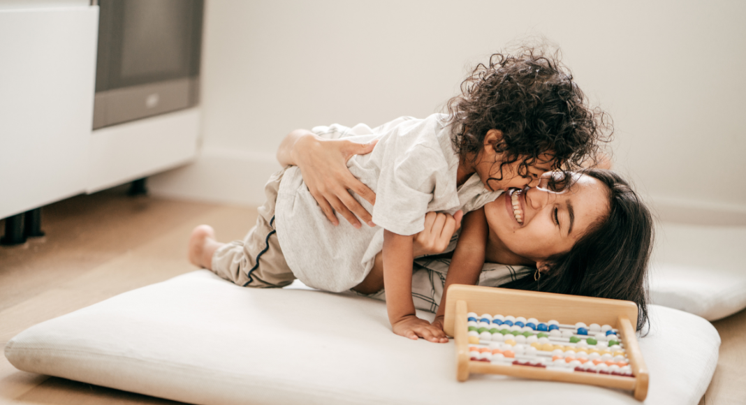 A mom cuddling her toddler son.