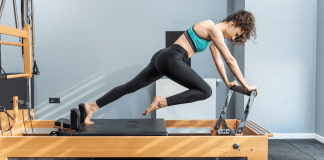 A woman working on Pilates equipment.