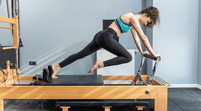 A woman working on Pilates equipment.