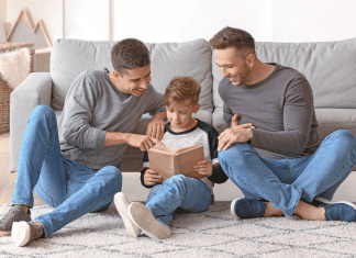 Two dads reading to their son.