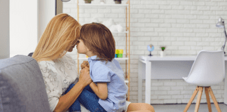 How to Handle Loss and Grief With Your Children A mom being comforted by her young son.