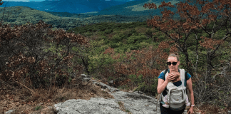 Tips for Hiking With Little Kids A woman hiking with her baby.