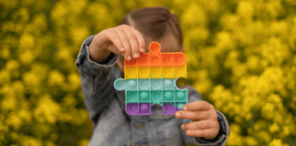 A child holding a pop-it sensory toy.