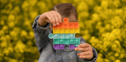 A child holding a pop-it sensory toy.