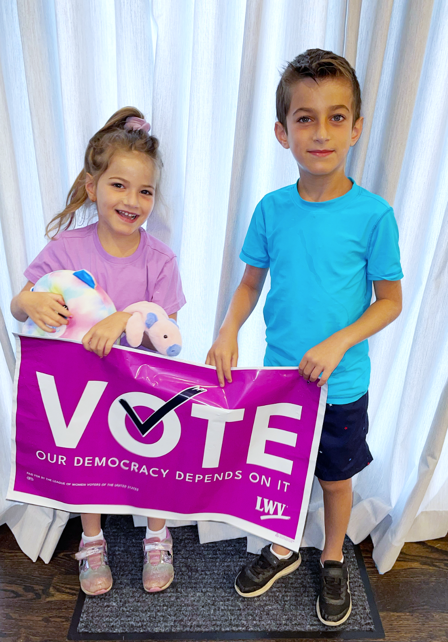 Kids holding a "VOTE" sign.