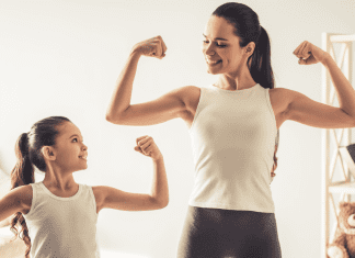 A mom and daughter making muscles.