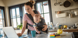 Motherhood Mantra: I Can Only Do One Thing at a Time A mom carrying a baby and checking her email on the computer.