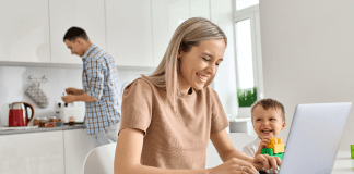 A woman working while her husband makes breakfast.