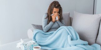 A woman with a cold blowing her nose.